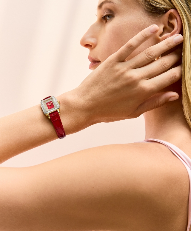 A woman wearing the Special Edition Deco Mini Pavé watch featuring a Ruby Red mother-of-pearl and pavé dial and Ruby Red croco-embossed leather strap.