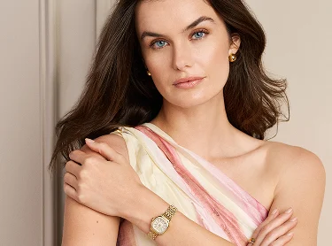 Model wearing Meggie Mini gold with feature shots of the Deco Madison Mini, Serein Oval, and Deco Park to the right