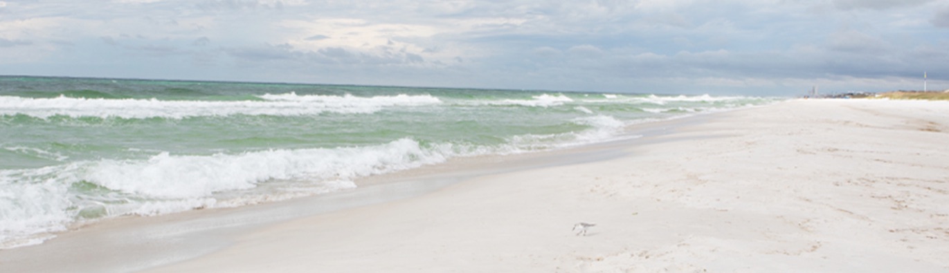 Beautiful view of sand-lined beach and crystal-green waters on Alys Beach.