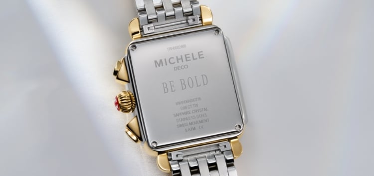 The phrase Be Bold engraved on the back of a MICHELE watch