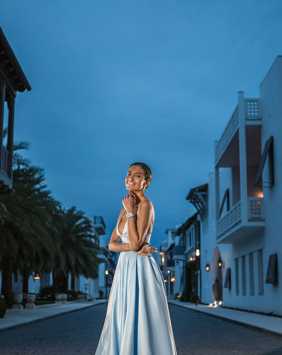 Elegant woman wearing ball gown and limited-edition Deco watch coverd in diamonds and sky blue dial with sapphires.
