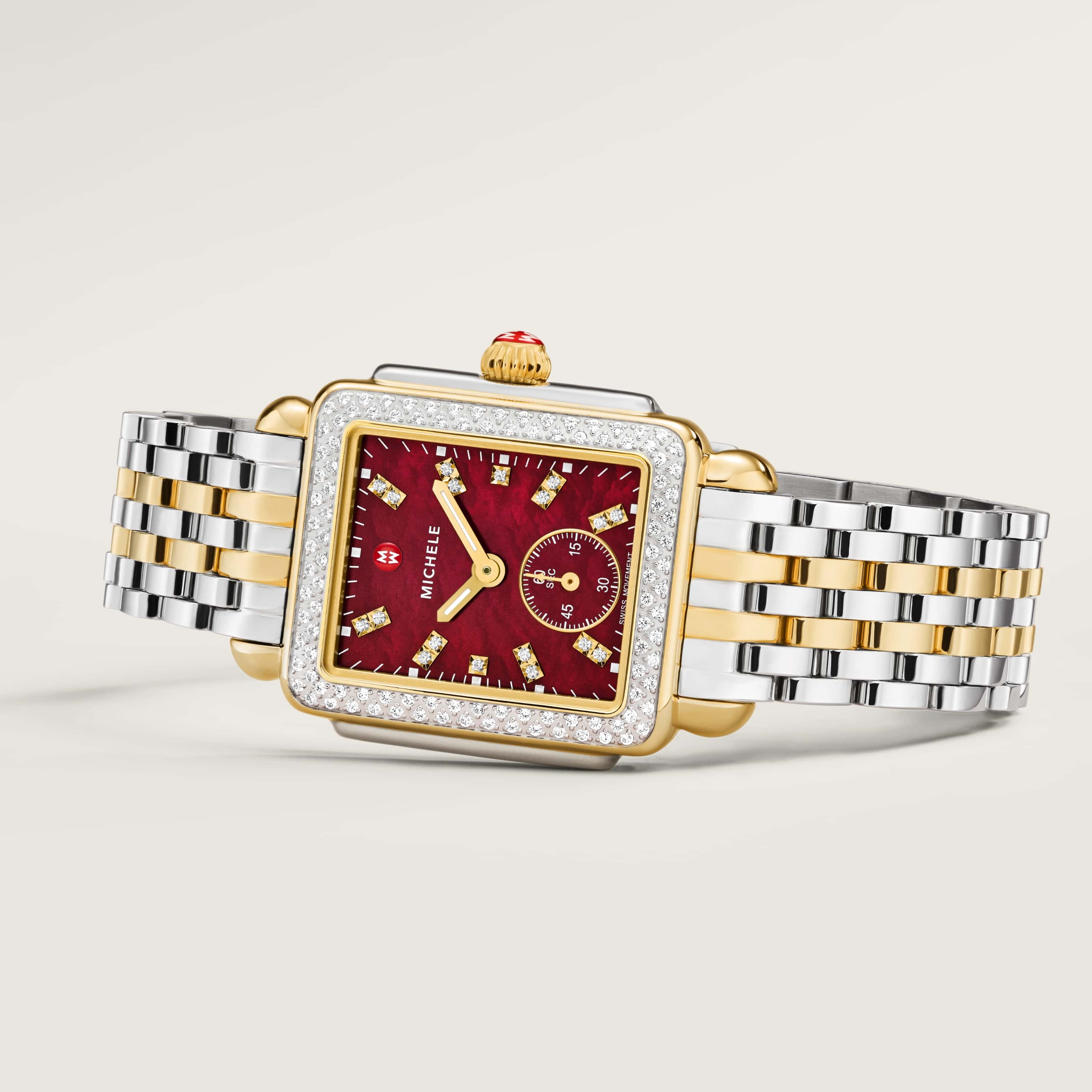 Woman wearing a Deco Mid Ruby watch in two-tone with a ruby red face and double diamond indexes