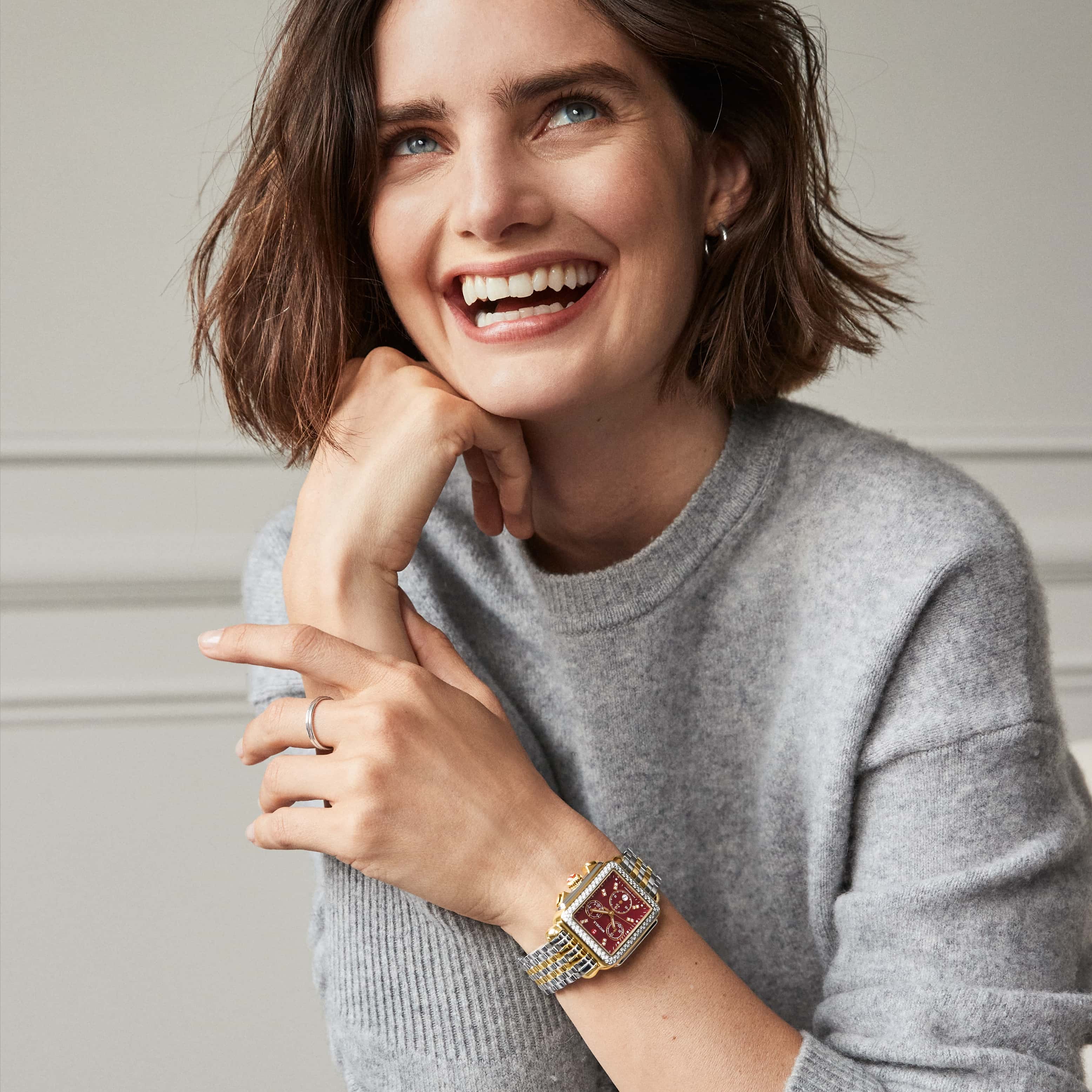 Woman wearing a Deco Ruby Diamond watch in two-tone with a ruby red face and double diamond indexes