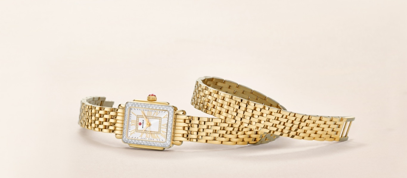 Deco Madison Mini watch in 18k gold features a mother-of-pearl dial with gold Roman numeral indexes, diamond-covered bezel and 18k gold seven-link double-wrap bracelet.